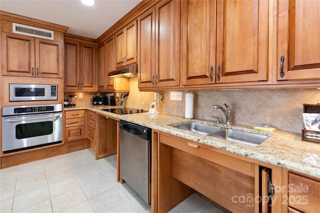 kitchen with tasteful backsplash, visible vents, appliances with stainless steel finishes, under cabinet range hood, and a sink