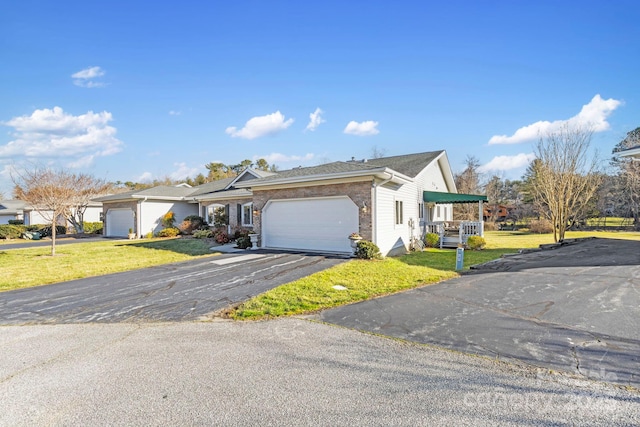 ranch-style home with driveway, brick siding, an attached garage, and a front lawn