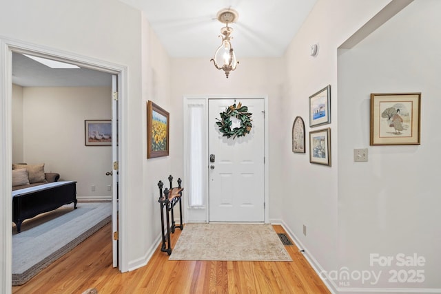 foyer entrance with light wood-type flooring and baseboards