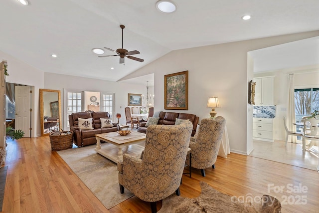 living room with light wood-style flooring, lofted ceiling, and a healthy amount of sunlight