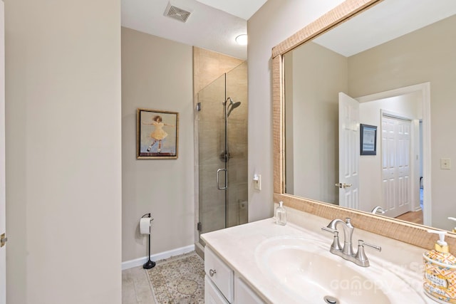 bathroom with vanity, baseboards, visible vents, and a stall shower