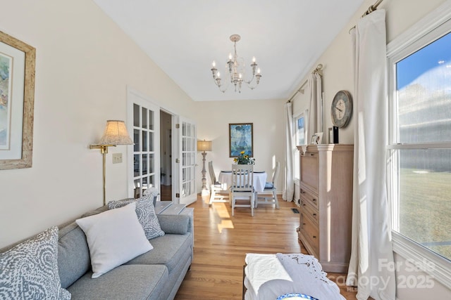 living area with french doors, an inviting chandelier, and wood finished floors