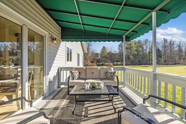 wooden deck with an outdoor living space and a lawn