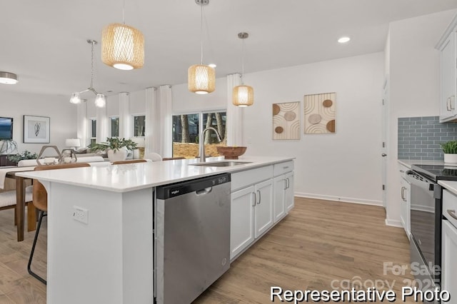 kitchen featuring a breakfast bar area, a sink, white cabinets, appliances with stainless steel finishes, and an island with sink