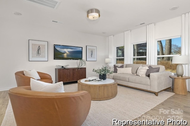 living room with light wood finished floors and visible vents