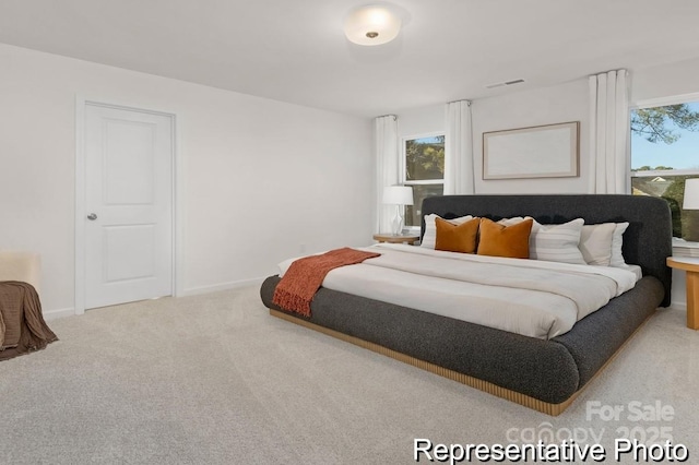 bedroom with baseboards, multiple windows, visible vents, and light colored carpet