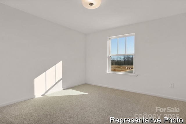 empty room featuring baseboards and light colored carpet