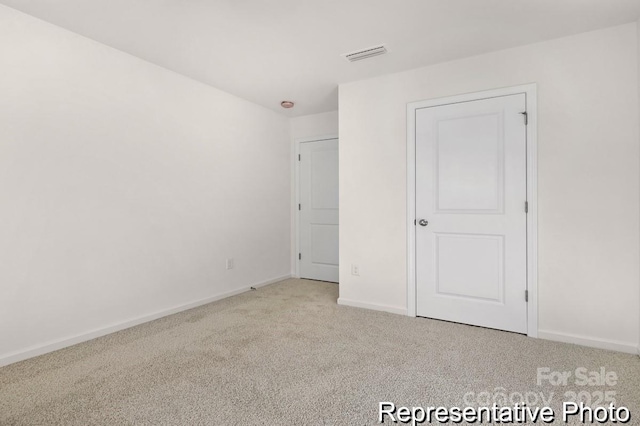 unfurnished bedroom featuring visible vents, light carpet, and baseboards