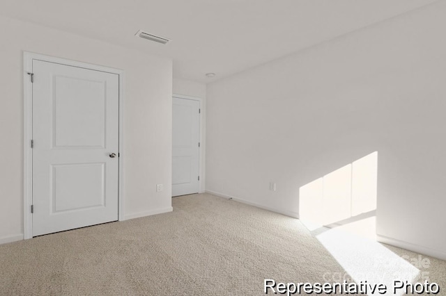 unfurnished bedroom with baseboards, visible vents, and light colored carpet