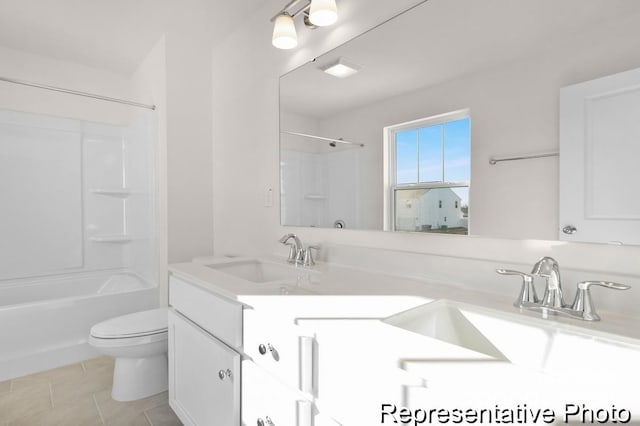 full bathroom with washtub / shower combination, vanity, toilet, and tile patterned floors