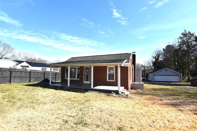 rear view of house featuring brick siding, a porch, a lawn, fence, and a garage