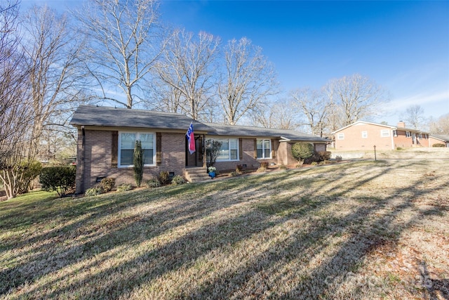 view of front of home with brick siding, crawl space, and a front yard