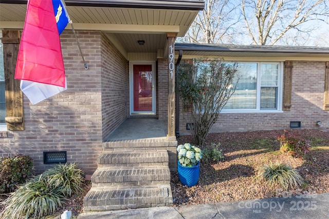 doorway to property with crawl space and brick siding