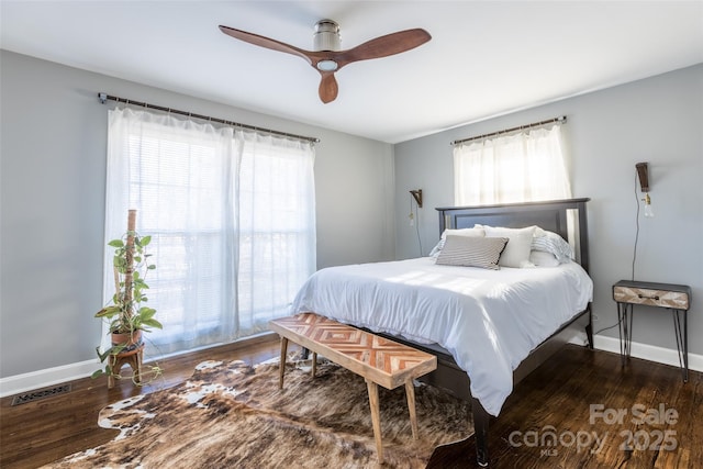 bedroom featuring dark wood-type flooring, visible vents, baseboards, and multiple windows