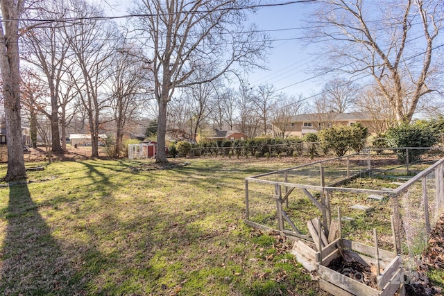 view of yard featuring a garden, fence, and a shed