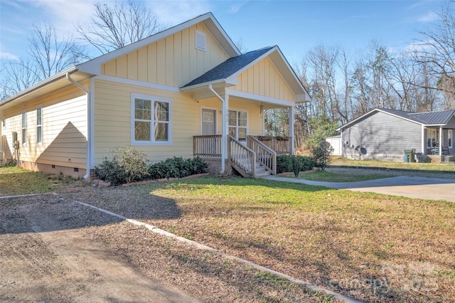 view of front of home featuring a porch, a shingled roof, crawl space, a front lawn, and board and batten siding