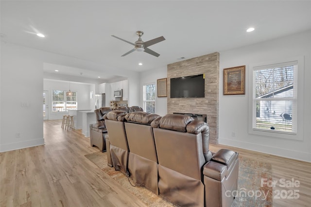 living area with light wood finished floors, baseboards, a ceiling fan, and recessed lighting