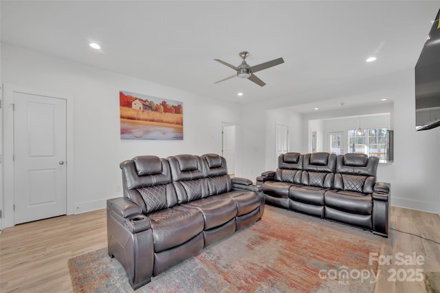 living room featuring baseboards, light wood-type flooring, and recessed lighting