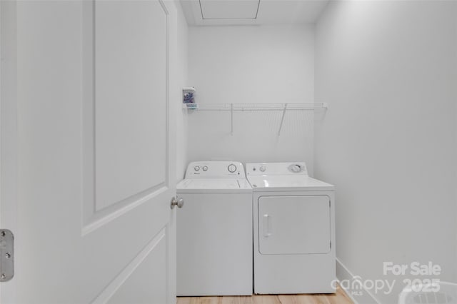 clothes washing area with laundry area, washer and clothes dryer, and light wood finished floors