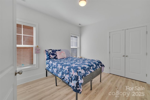 bedroom featuring a closet, baseboards, and wood finished floors