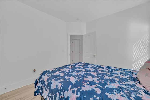 bedroom with baseboards and wood finished floors