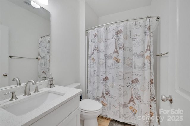 bathroom with wood finished floors, curtained shower, vanity, and toilet