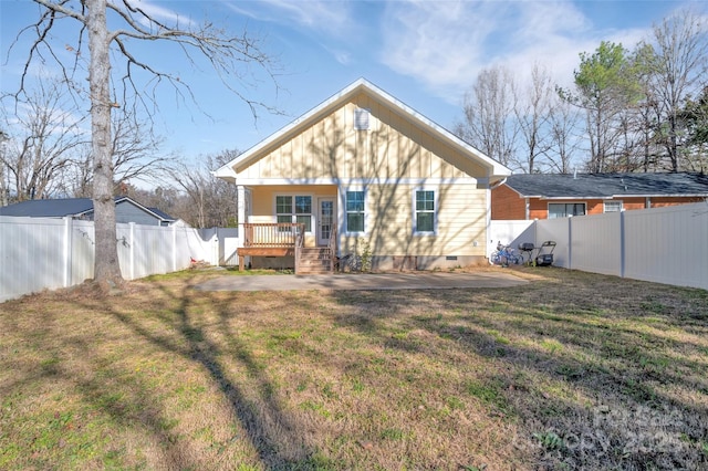 rear view of house featuring a porch, crawl space, a fenced backyard, and a yard