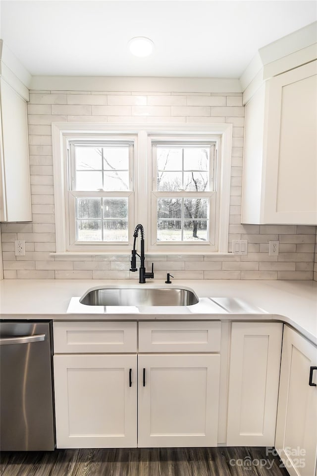 kitchen featuring dishwasher, a sink, white cabinetry, and a healthy amount of sunlight