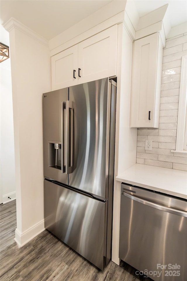 kitchen with stainless steel appliances, light countertops, white cabinetry, and tasteful backsplash