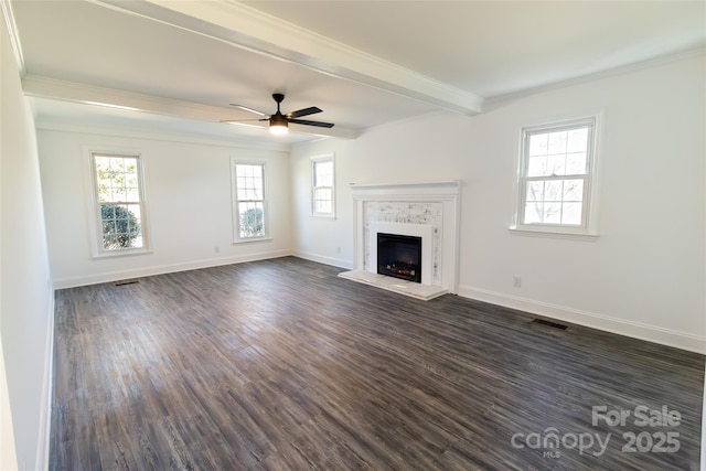 unfurnished living room with ceiling fan, a fireplace, baseboards, beamed ceiling, and dark wood finished floors