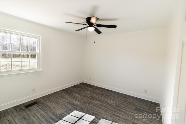 unfurnished room with baseboards, dark wood-type flooring, visible vents, and crown molding