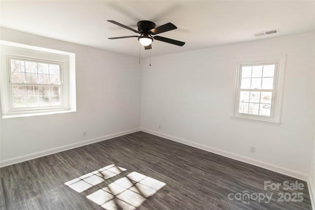 empty room with visible vents, dark wood finished floors, baseboards, and ceiling fan