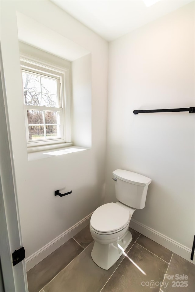 bathroom featuring baseboards, toilet, and tile patterned floors