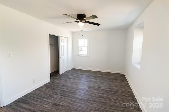 unfurnished bedroom with ceiling fan, a closet, baseboards, and dark wood-style flooring