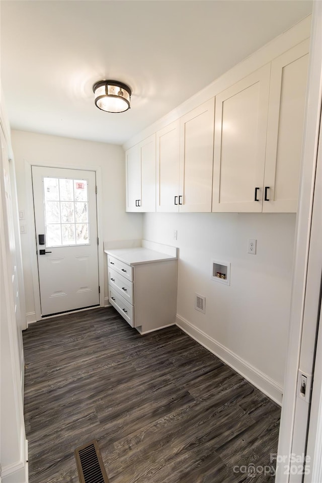 clothes washing area featuring dark wood-style floors, visible vents, washer hookup, and cabinet space