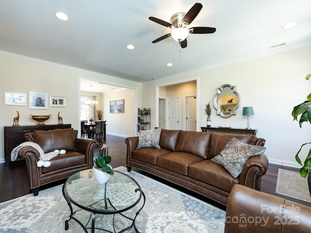 living area with recessed lighting, wood finished floors, visible vents, baseboards, and crown molding