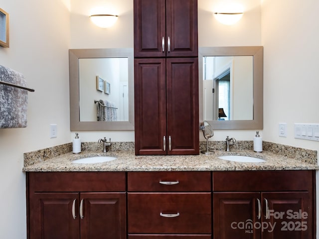 full bathroom with double vanity and a sink