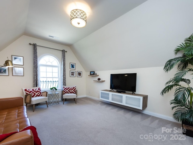 sitting room with vaulted ceiling, carpet floors, visible vents, and baseboards