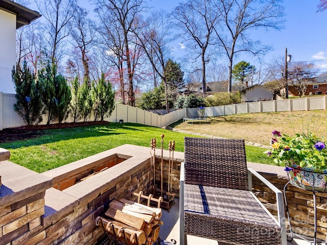 exterior space featuring a fenced backyard, a trampoline, and a lawn