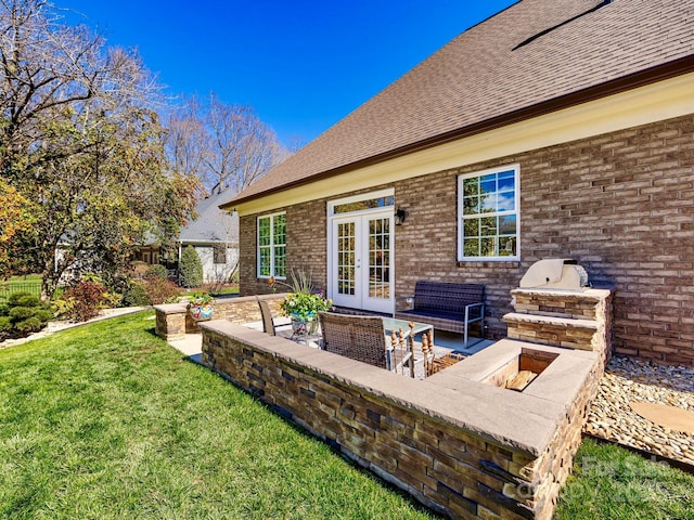 exterior space with french doors, brick siding, a lawn, a patio area, and an outdoor living space