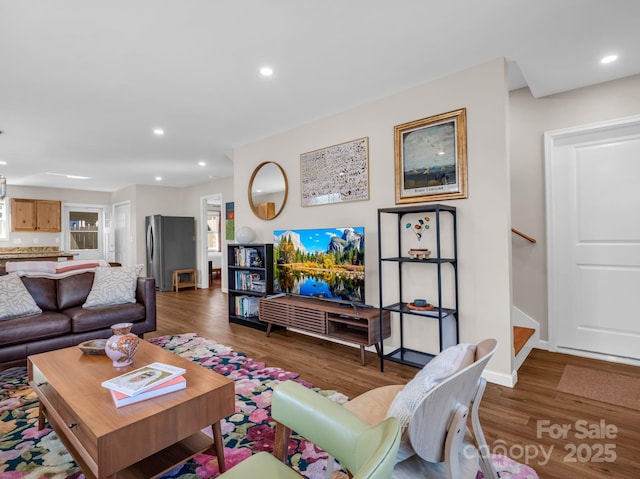 living room with recessed lighting, stairway, baseboards, and wood finished floors