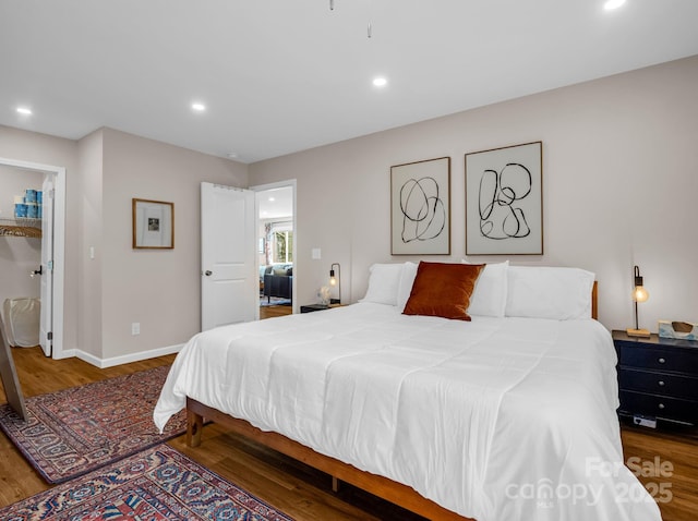 bedroom with baseboards, wood finished floors, and recessed lighting