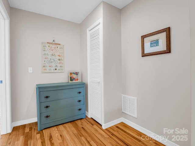 interior space with light wood finished floors, visible vents, and baseboards