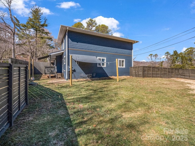 back of property featuring a fenced backyard and a yard