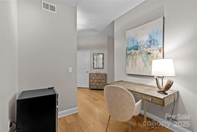 office featuring light wood-type flooring, visible vents, and baseboards