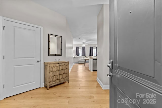 corridor with light wood finished floors and baseboards