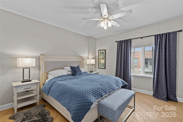 bedroom featuring a ceiling fan, light wood-style flooring, and baseboards