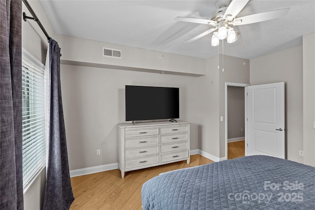 bedroom with light wood-style flooring, a ceiling fan, visible vents, and baseboards