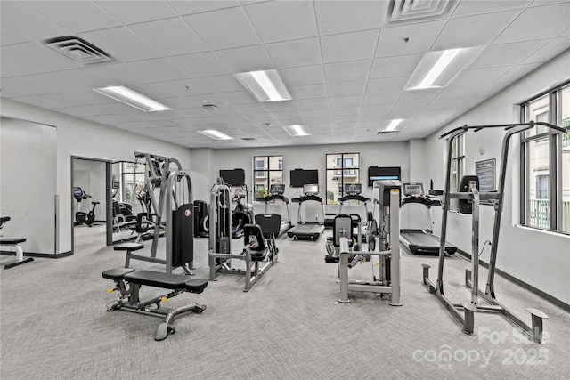 gym with visible vents, light carpet, baseboards, and a drop ceiling