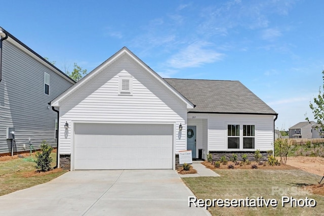 view of front of property featuring a shingled roof, concrete driveway, and an attached garage